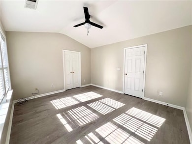 Unfurnished bedroom featuring lofted ceiling, a ceiling fan, wood finished floors, and a closet
