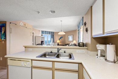 Kitchen featuring dishwasher, light countertops, a sink, white cabinetry, and a textured ceiling