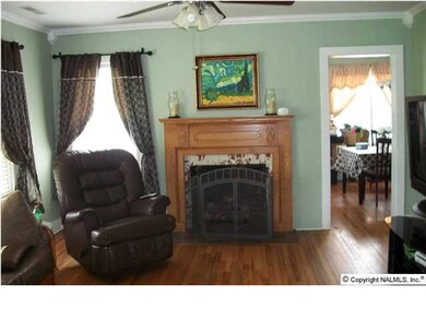 Living Room with hardwood flooring, gas logs, new mantel and ceiling fan.