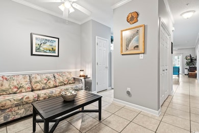 Living area featuring crown molding, light tile pa