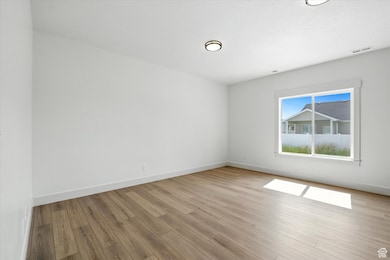 Unfurnished room with baseboards and light wood finished floors
