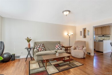 Hardwood floors gleam in this quite wide room offe