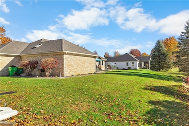 View of property exterior featuring brick siding, a lawn, and a patio
