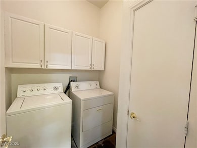 Washroom featuring cabinet space and washer and cl