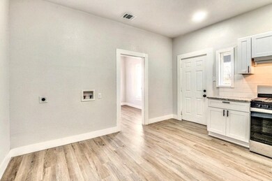 Kitchen featuring gas stove, light stone counters,