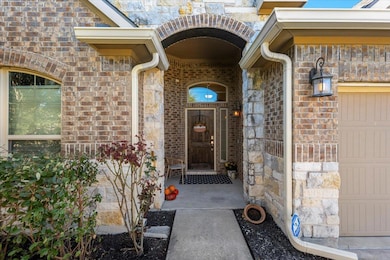 Doorway to property with stone siding and brick s