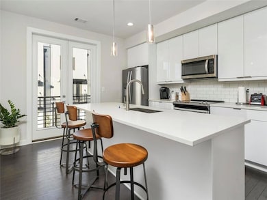 Kitchen with appliances with stainless steel finishes, backsplash, a kitchen bar, dark wood-type flooring, and recessed lighting