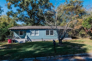 View of side of property with crawl space, a yard, and roof with shingles