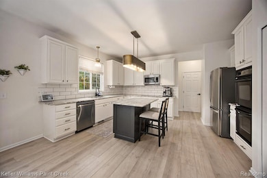 Updated kitchen with marble countertops and stainless steel appliances.