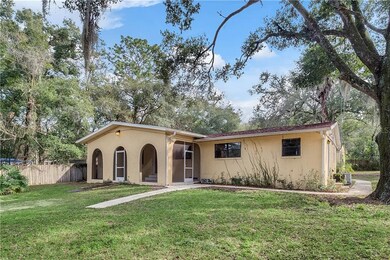 A massive screened-in front porch looks onto a lar