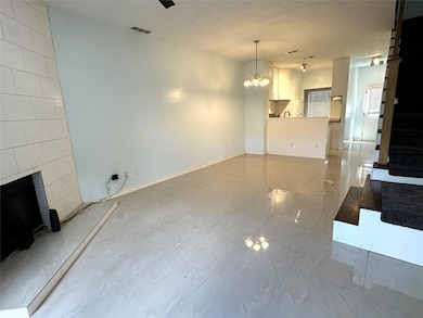 Unfurnished living room with a chandelier and a fi