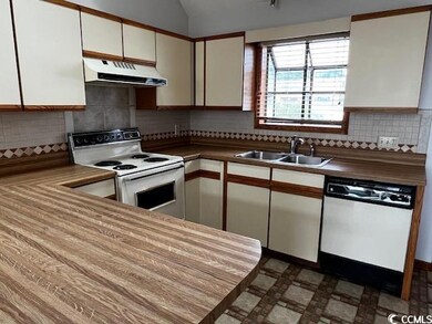 Kitchen featuring sink, white cabinetry, tasteful 