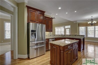 The gourmet kitchen features deeply paneled hardwo