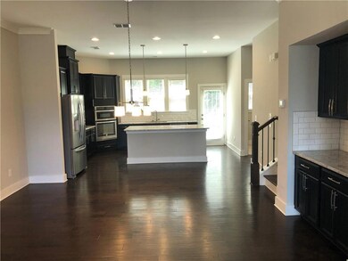 Kitchen with appliances with stainless steel finishes, decorative backsplash, dark wood-type flooring, a center island, and dark cabinetry