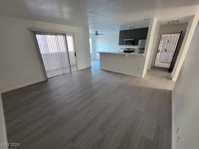 Unfurnished living room with wood finished floors, baseboards, and a sink