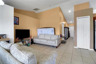 Living area featuring vaulted ceiling, light tile patterned floors, and recessed lighting