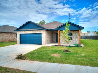 View of front of property with a garage, brick siding, driveway, and board and batten siding