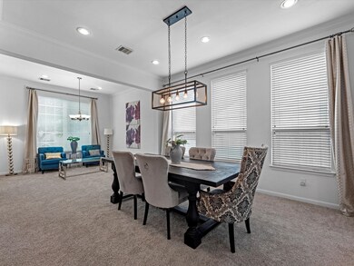 Elegant formal dining w/ a stylish light fixture.