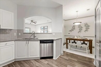 Kitchen with sink, white cabinetry, decorative bac
