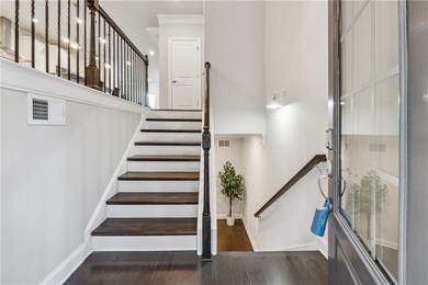 Stairs featuring wood finished floors and crown molding