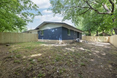 Back of house with a fenced backyard and brick siding