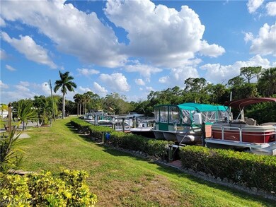 View of community featuring a dock, a lawn, view of scattered trees, and boat lift