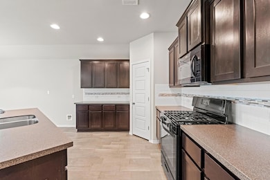Kitchen featuring black gas range oven, dark brow