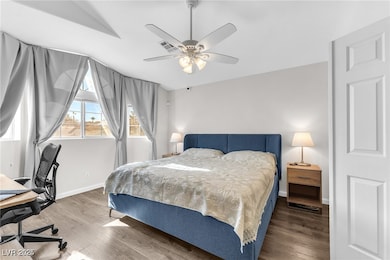 Bedroom featuring wood finished floors, an office