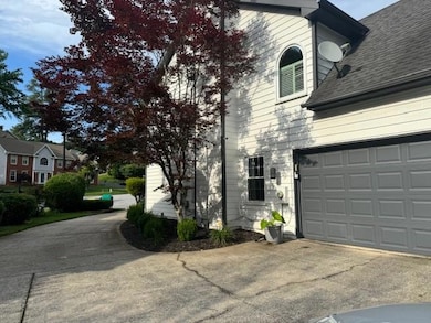 View of home's exterior featuring concrete driveway, a shingled roof, and a garage