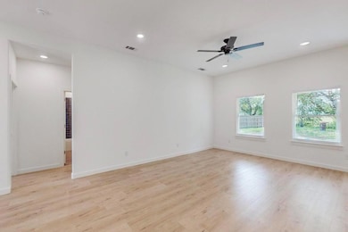 Unfurnished room with a ceiling fan, light wood-st