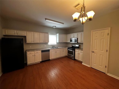 Kitchen featuring dark wood-style flooring, appli