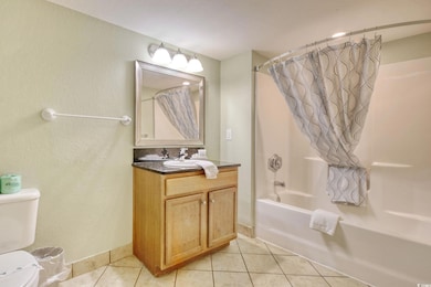 Main full bathroom featuring tub/shower combo, vanity and tile flooring.