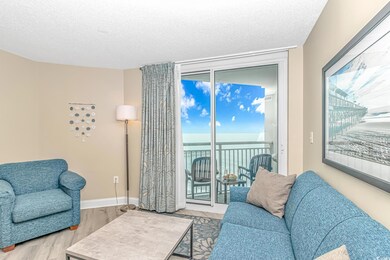 Living room with a water view, wood finished floors, and a textured ceiling