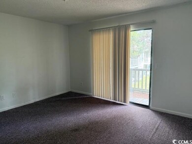 Carpeted empty room featuring a textured ceiling a