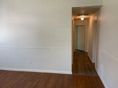 Spare room featuring wood finished floors and att