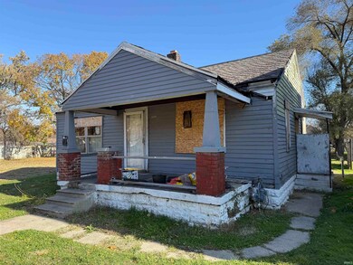 Bungalow with covered porch, a chimney, a shingled roof, and a front yard