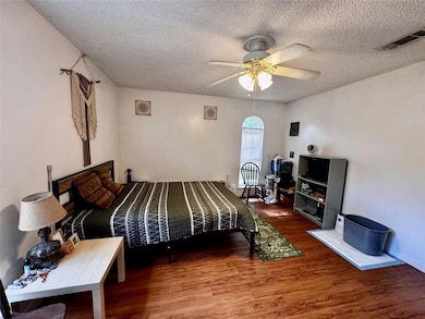 Bedroom featuring a ceiling fan, wood finished fl