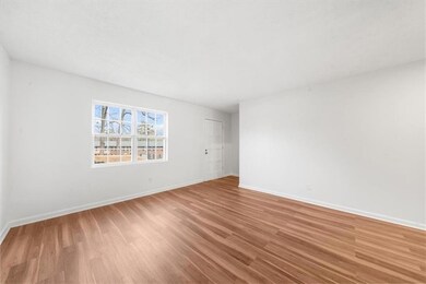 Unfurnished room with wood finished floors and baseboards