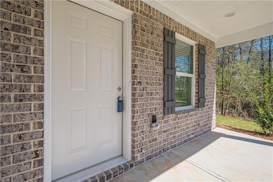 View of exterior entry with covered porch and bric