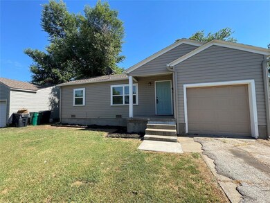 View of front facade featuring a garage and a front lawn
