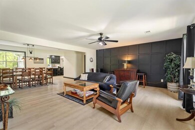 Living area featuring a decorative wall, a ceiling fan, and light wood-type flooring