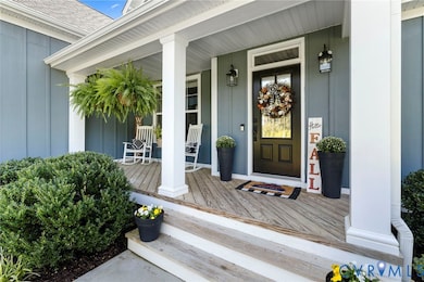 View of exterior entry featuring a porch, board and batten siding, and roof with shingles