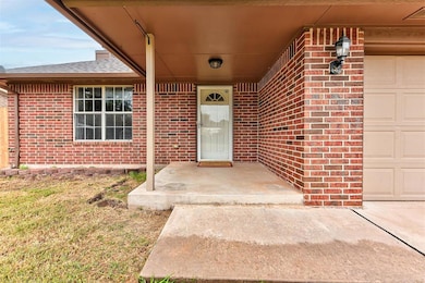 Entrance to property featuring brick siding, covered porch, a garage, and a shingled roof