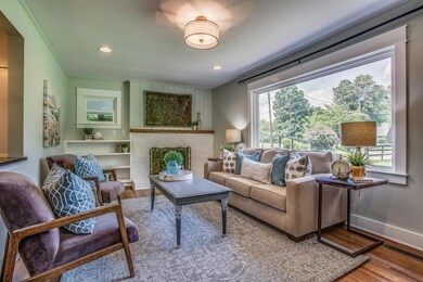 THIS HUGE NEW PICTURE WINDOW IN THE OPEN LIVING ROOM AFFORDS MUCH NATURAL LIGHT AND VIEWS OF THE LUSH SURROUNDINGS