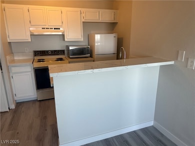 Kitchen featuring freestanding refrigerator, range