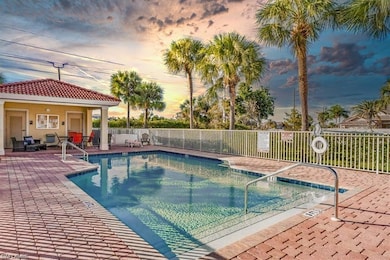 Pool at dusk with a community pool, fence, and a patio