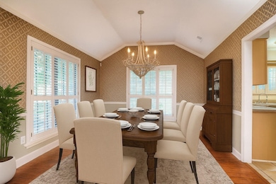 Formal Dining Room with a Soaring 10 Ft Coffered Ceiling, Hardwood Flooring, and Plantation Shutters—Perfect for Gatherings and Celebrations.