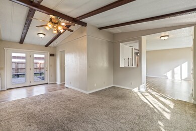 Empty room with a ceiling fan and carpet floors