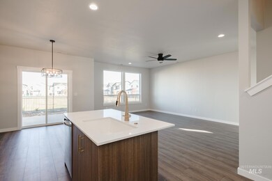 Kitchen with pendant lighting, open floor plan, recessed lighting, a center island with sink, and dark wood-style floors