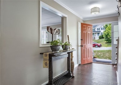 Entrance foyer with crown molding, wood-type floor